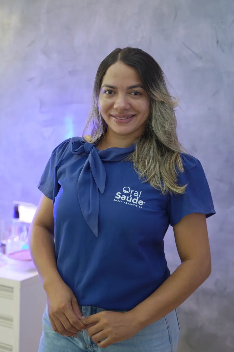 Integrante da equipe da Oral Saúde, de uniforme azul, na clínica